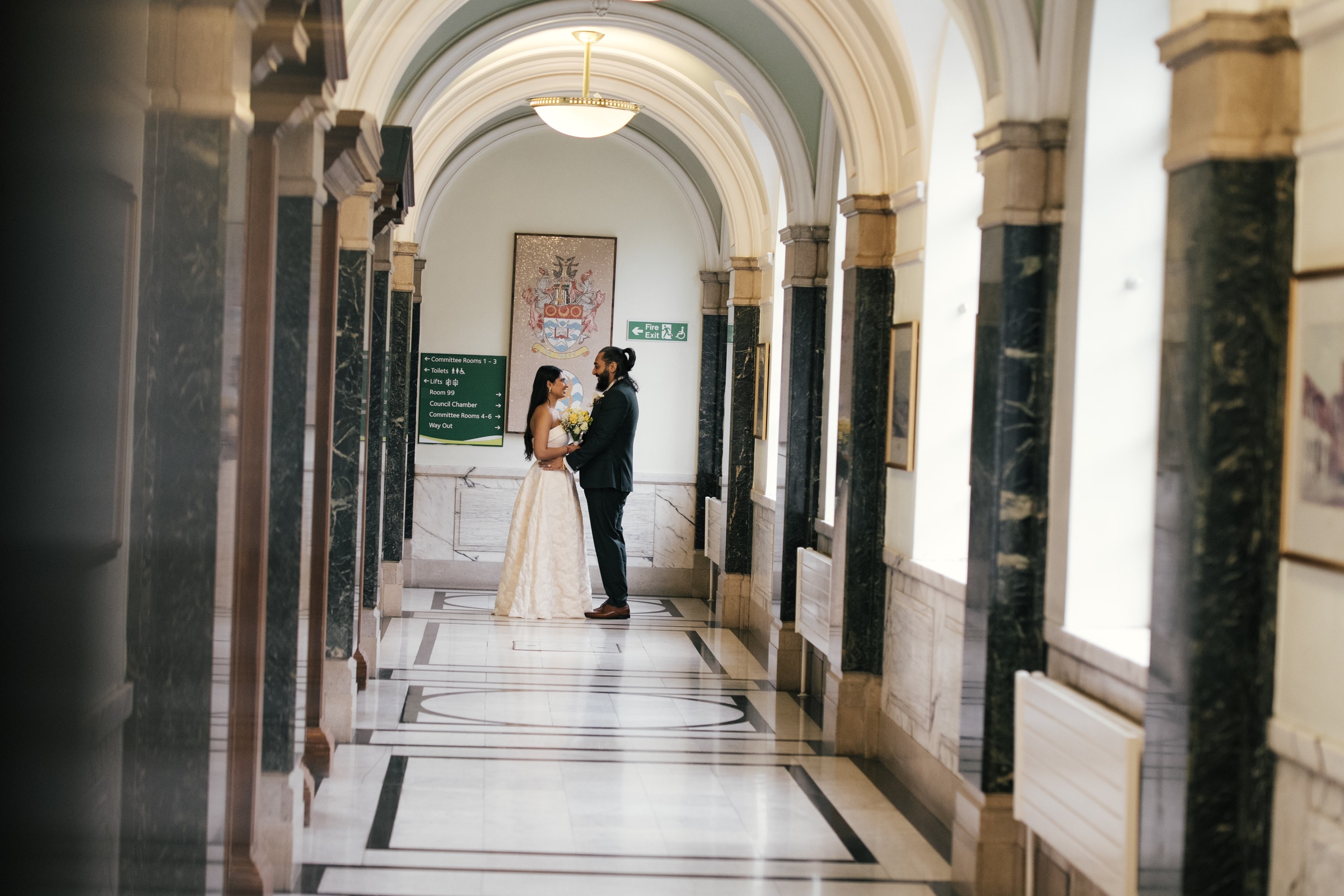 A couple standing together in a grand corridor