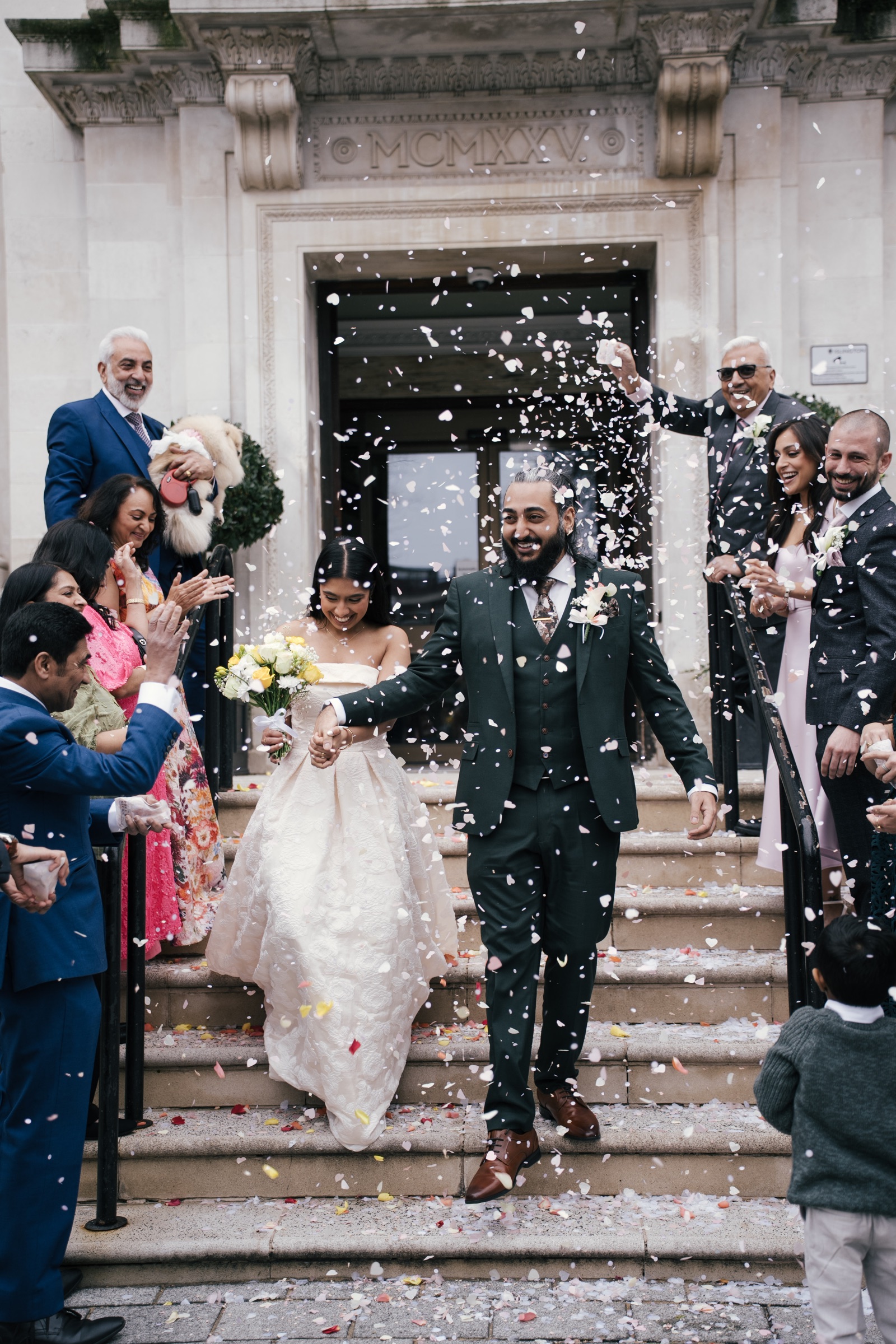 Newlyweds leaving their ceremony through falling petals